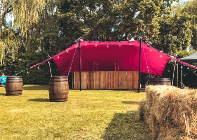 pink tent with whiskey barrels and bar