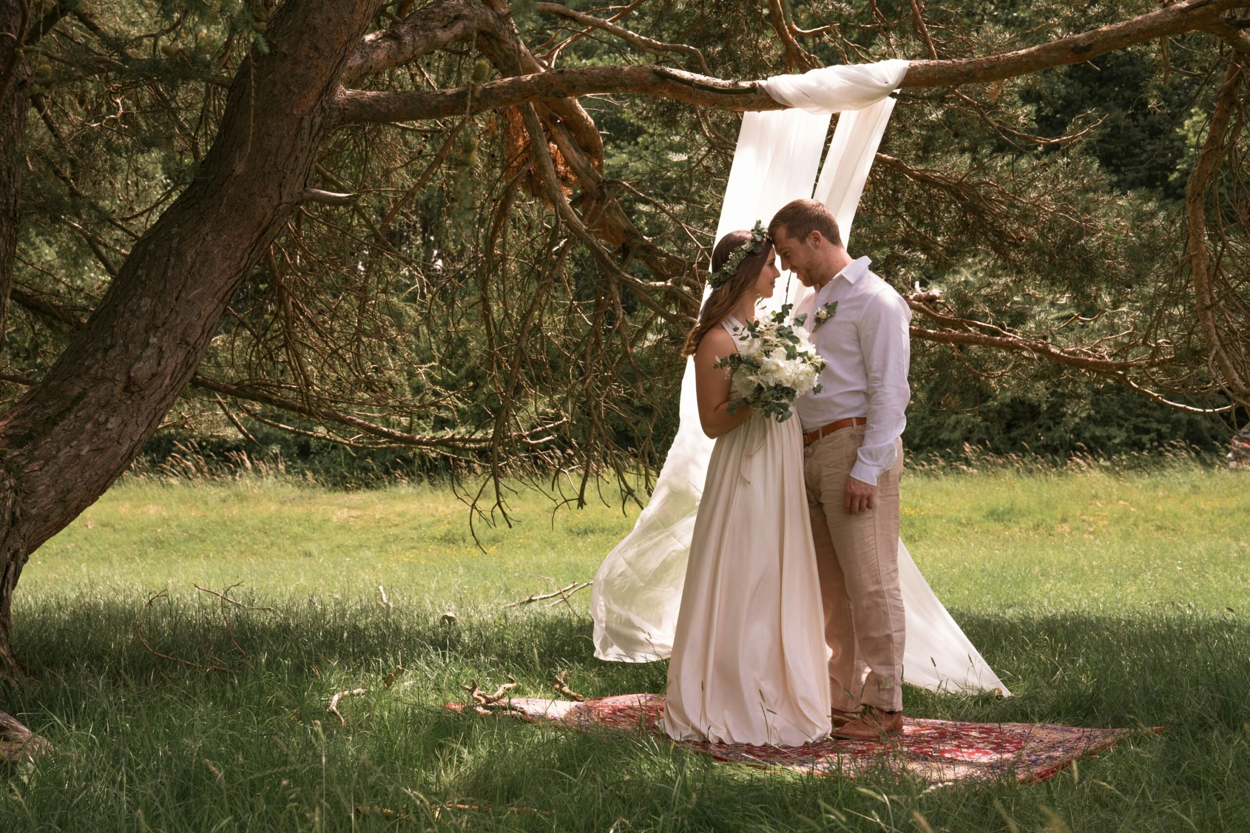 couple posed by tree at festival wedding